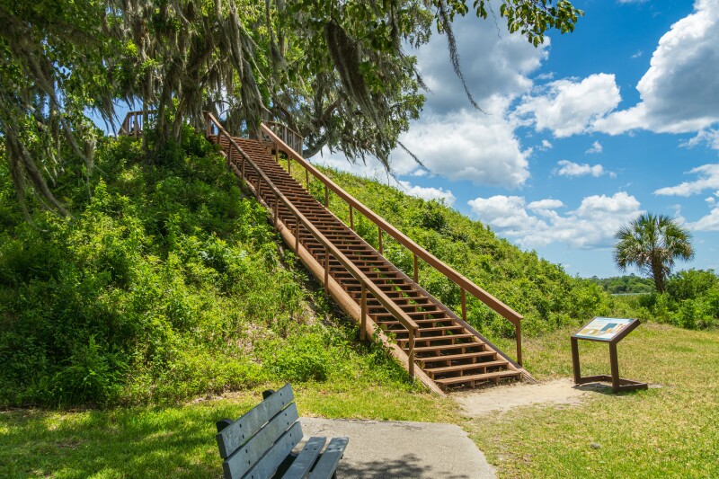 Outdoor stairs near wooden bench in shade