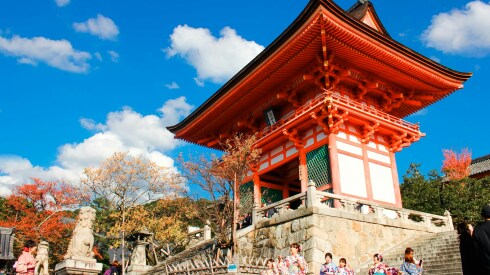 A group of young women dressed in yukatas in front of a shrine in Kyoto