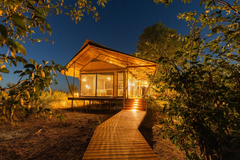 A tent illuminated at night at Wilderness Mokete in Botswana
