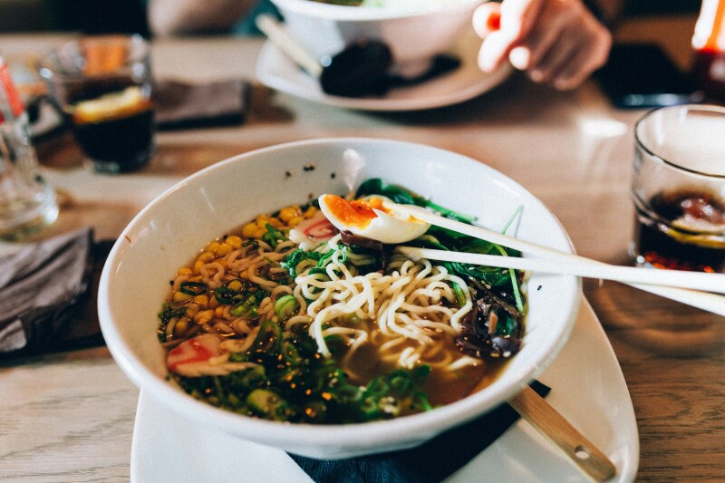 Close-up of a bowl of ramen with a soft-boiled egg and chopsticks