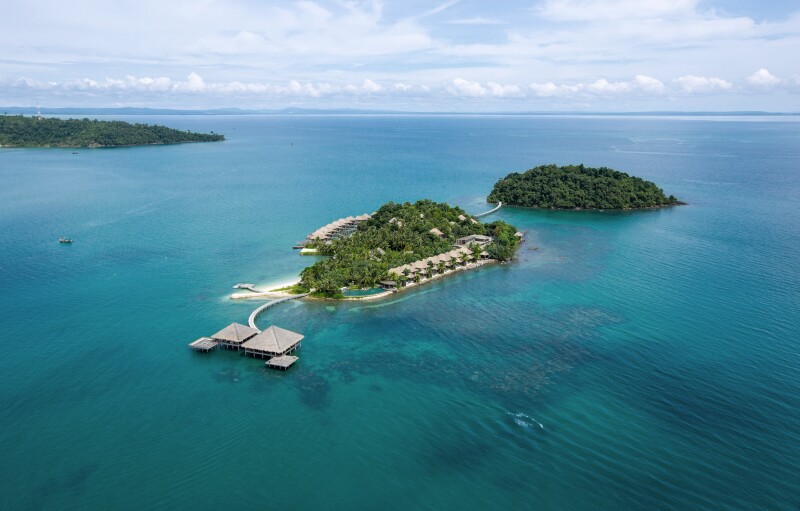 Distant aerial view of small Song Saa Private Island covered in green foliage and surrounded by Gulf of Thailand