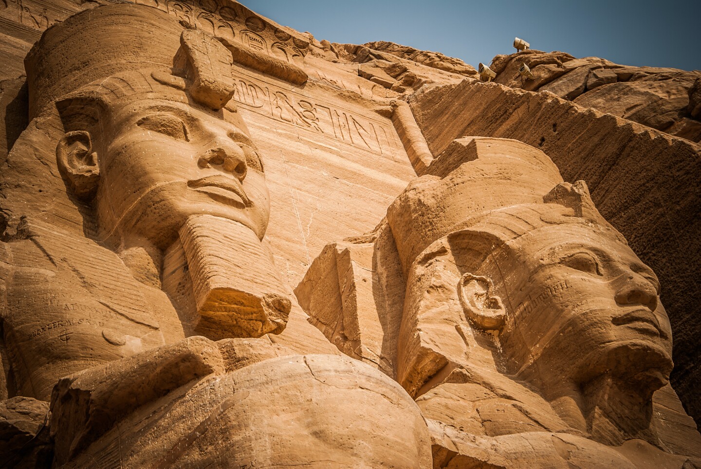 Closeup of giant carved heads of two pharaohs at Abu Simbel, Egypt