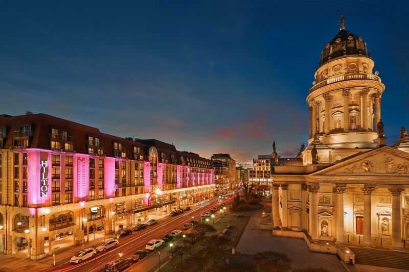 Pink lights shining on the facade of Mitte’s Hilton Berlin at dusk