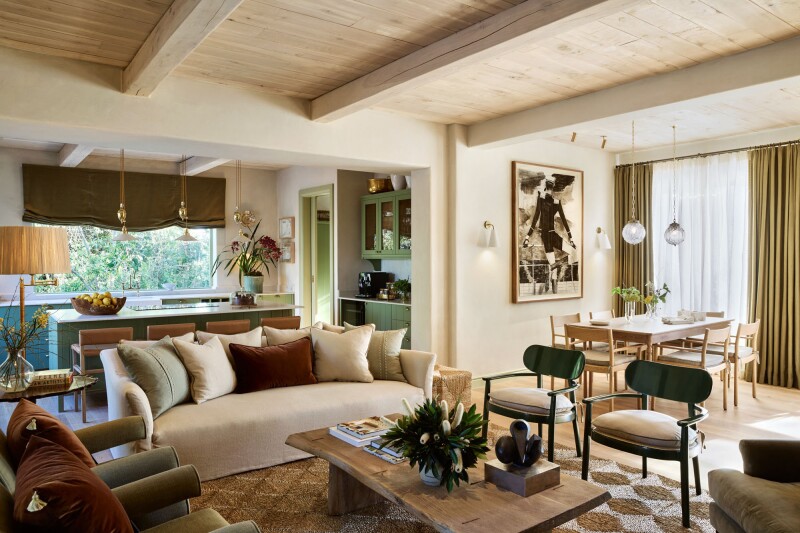 The Riverside Villa with a large sofa, wood beam ceilings, and wood floors