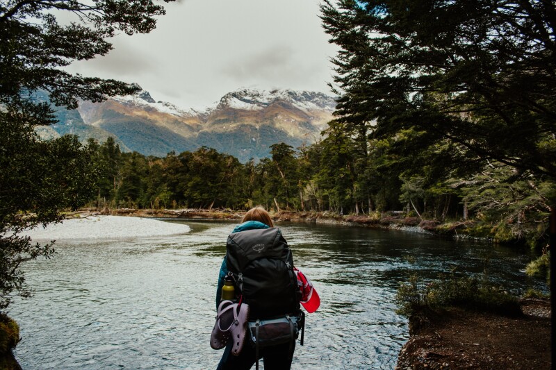 A gray mountain with snow and cloud-filled sky along the Milford Track