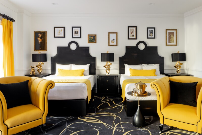 A guest room with two twin beds and black and yellow furnishings at the Vendue in Charleston