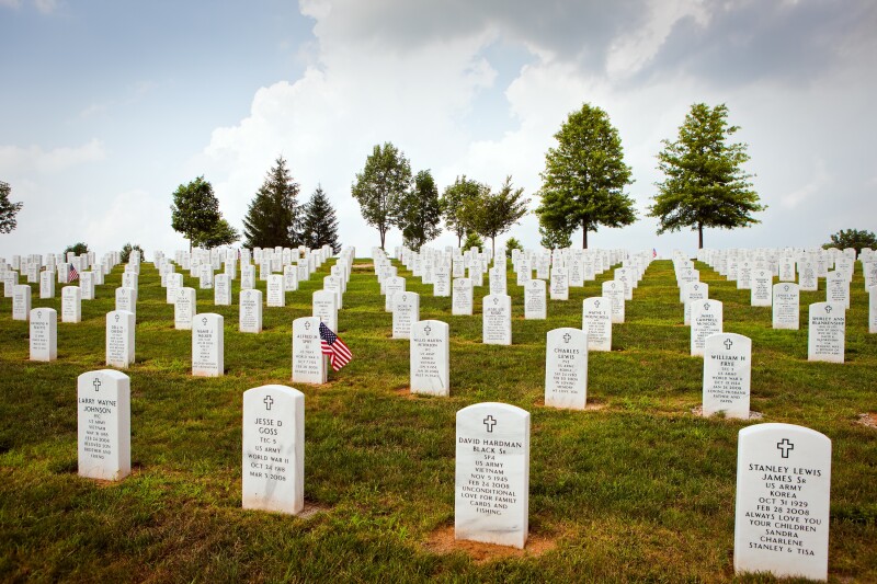White marble gravestones line a grassy hill at Camp Nelson National Cemetery