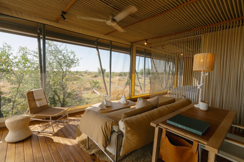 A lounge area in a tent at Wilderness Mokete in Botswana with views of the surrounding landscape