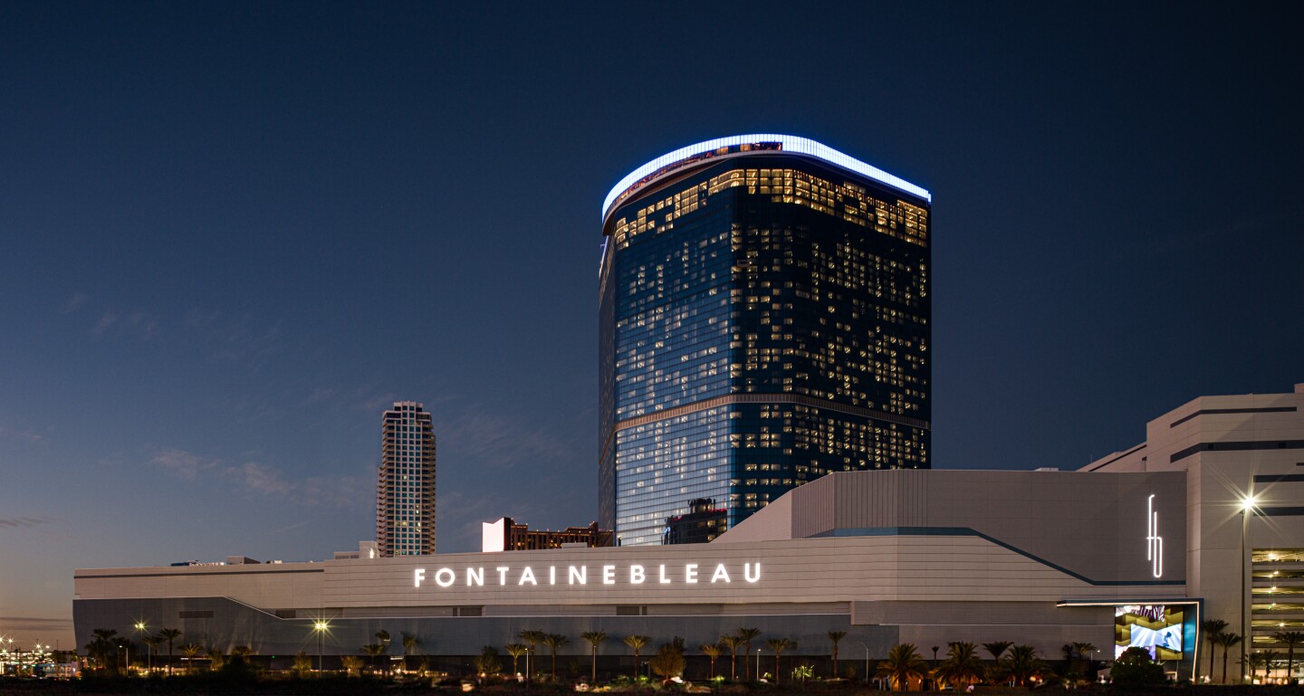 Skyscraper and white building with the word "Fonatainebleau" at night