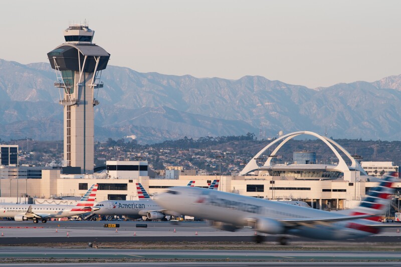 The Theme Building at Los Angeles International Airport is situated between a runway and the San Gabriel mountains.