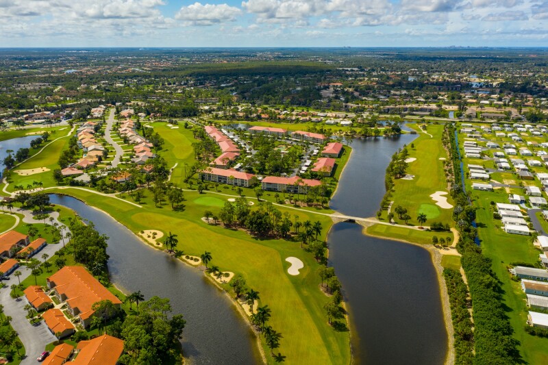 Aerial view of golf course and ponds among houses