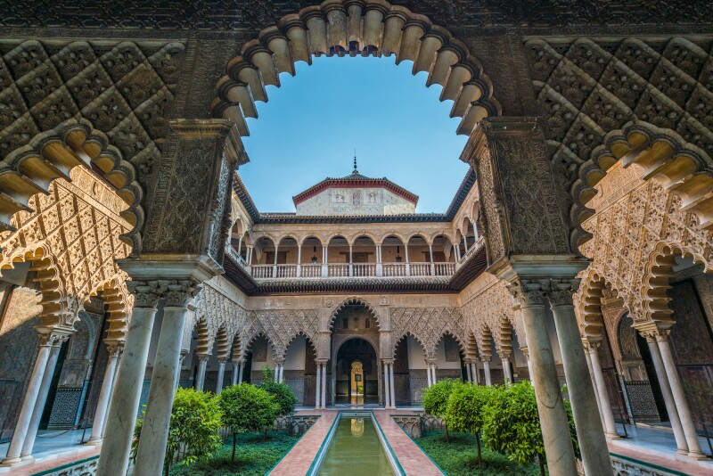 Inner courtyard at the Alcázar of Seville, surrounded by loggias of pointed arches