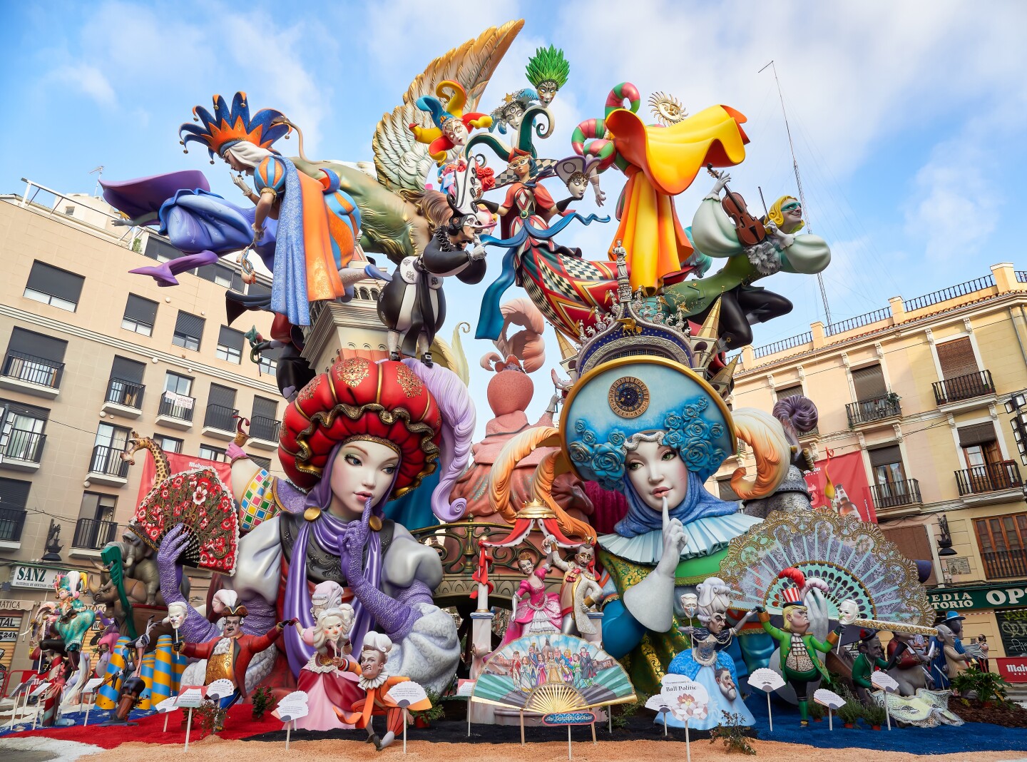 Multicolored float with two people in costume attire as the centerpiece