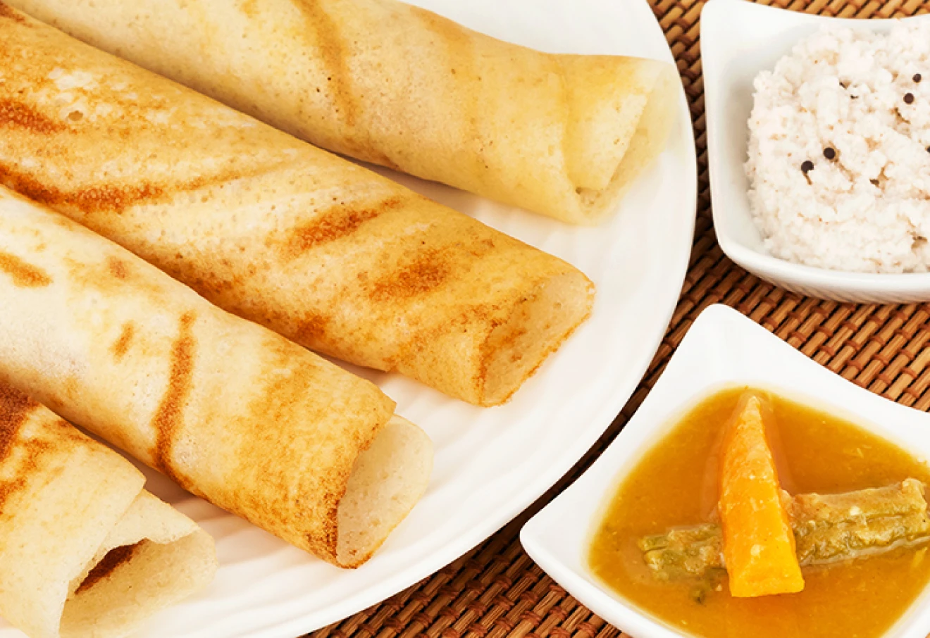 A traditional ethnic south Indian breakfast of Dosa (Dosai) served with coconut chutney and sambar.