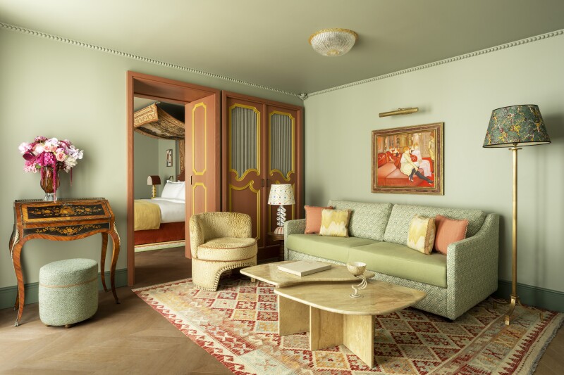 Guest room, with pale green furnishings and walls, sofa, and folding door to bedroom