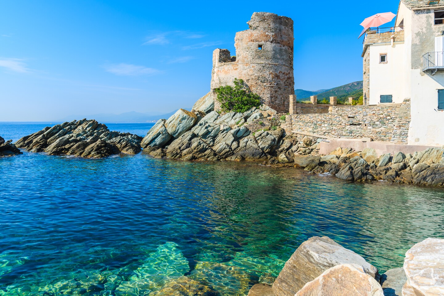 Shallow cove off Corsica, with old stone buildings in background