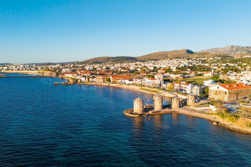 Aerial view of Chios and sea, with several windmills near foreground