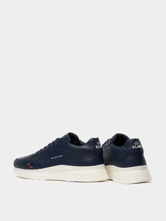 KLM flight attendant sneakers that are black with white soles and have the KLM logo on the back