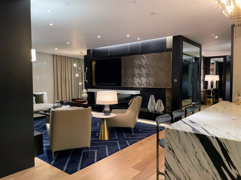 A "prestige" suite at Capella Sydney, with contemporary decor and navy blue rug on wooden floor