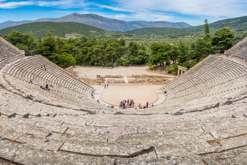 Small group of tourists near stage of amphitheater of the Sanctuary of Asklepios at Epidaurus
