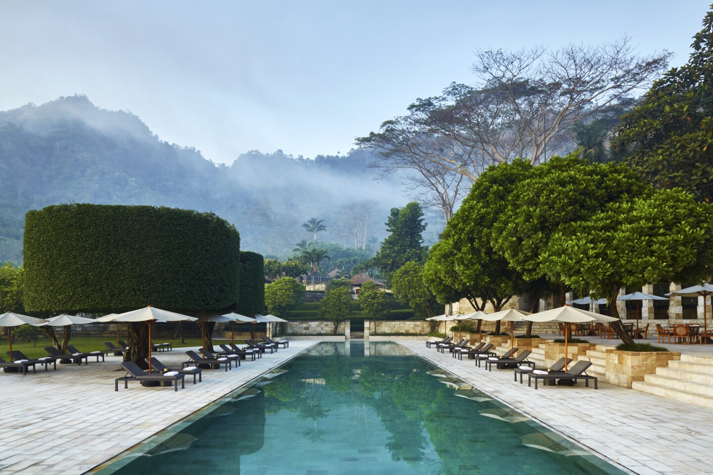 The main swimming pool at Amanjiwo has views of green mountains.
