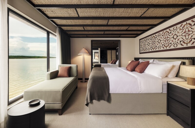 A room with a large bed facing the window on the 'Pure Amazon' riverboat