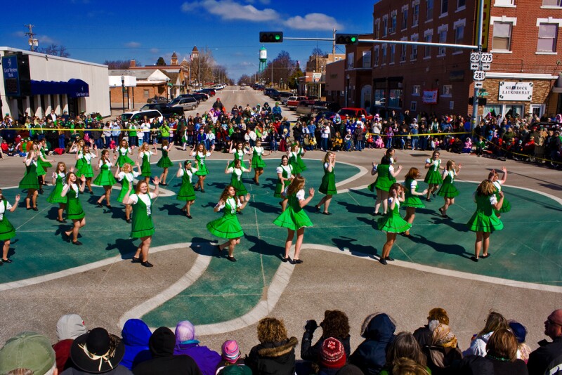 O’Neill’s famous painted shamrock on street with dancers in green dresses