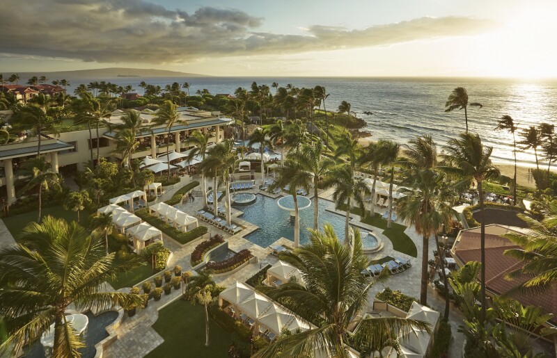 Aerial view of the pool area at Four Seasons Resort Maui at Wailea with palm trees all around