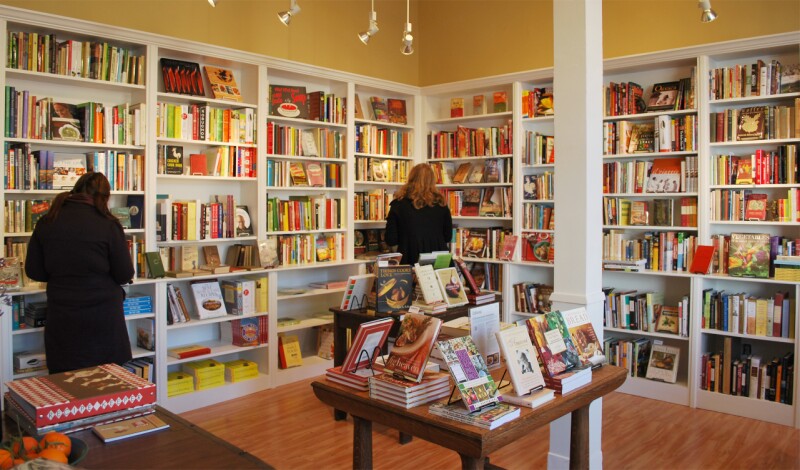 People browsing books on white shelves at Omnivore bookstore in San Francisco