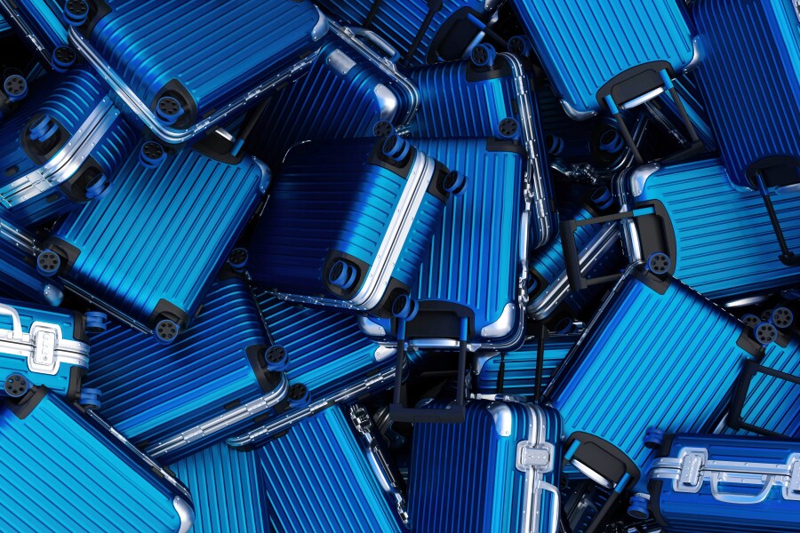 A pile of metallic blue suitcases