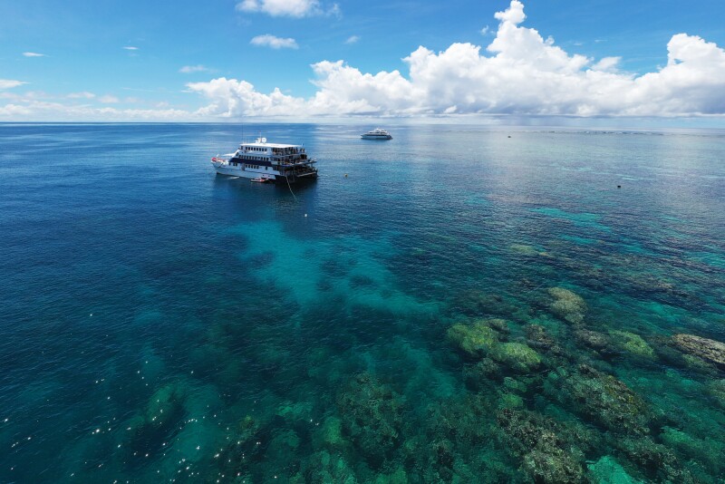 Small liveaboard boat in shallow water in Great Barrier Reef