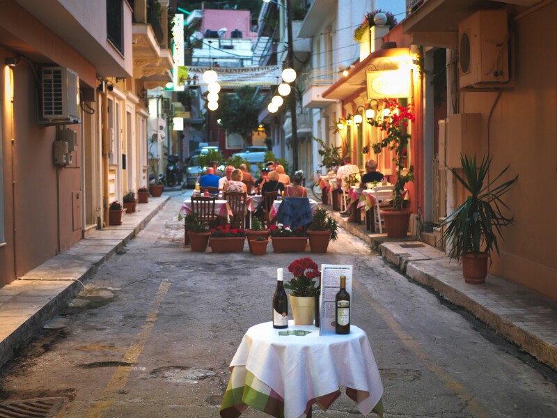 Diners at dusk outside a restaurant on a Zakynthos street limited to pedestrians