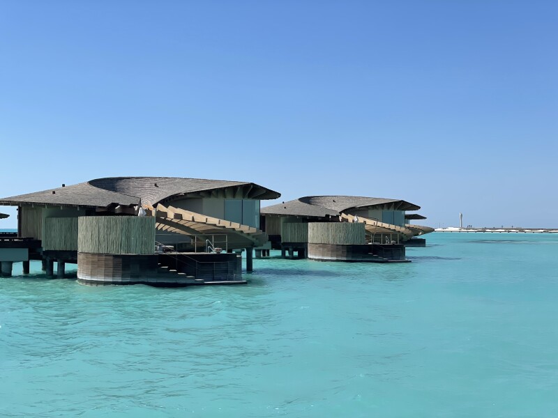 The overwater bungalows at St. Regis Red Sea Resort in Saudi Arabia are surrounded by blue waters.