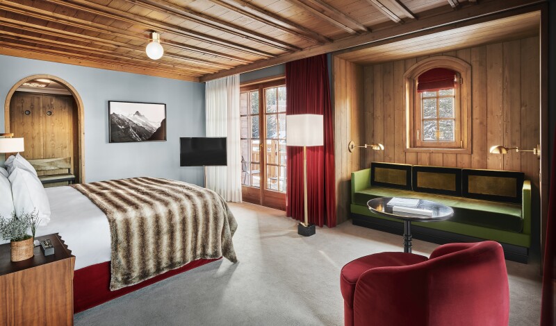 A chalet room at L'Apogee Courchevel with wood beam ceilings and French doors