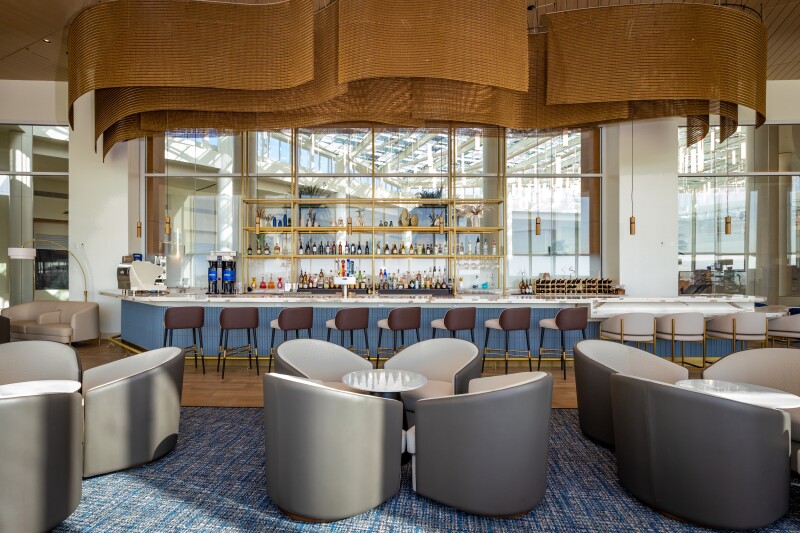 Orlando Plaza Premium Lounge Bar, with curved gray and white seats and bar in background