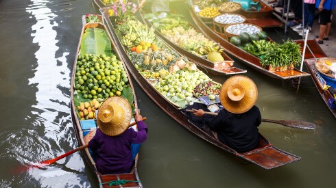 Small boats carrying produce in the floating market of Damnoen Saduak in Ratchaburi, Thailand.