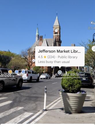 Google Maps screenshot showing Google Maps Lens feature, which puts icons on top of buildings as you look at them on your phone. This picture shows a street in Manhattan with castle-like brick library buildings and a pop-up dialog box that names the building as Jefferson Market Library.