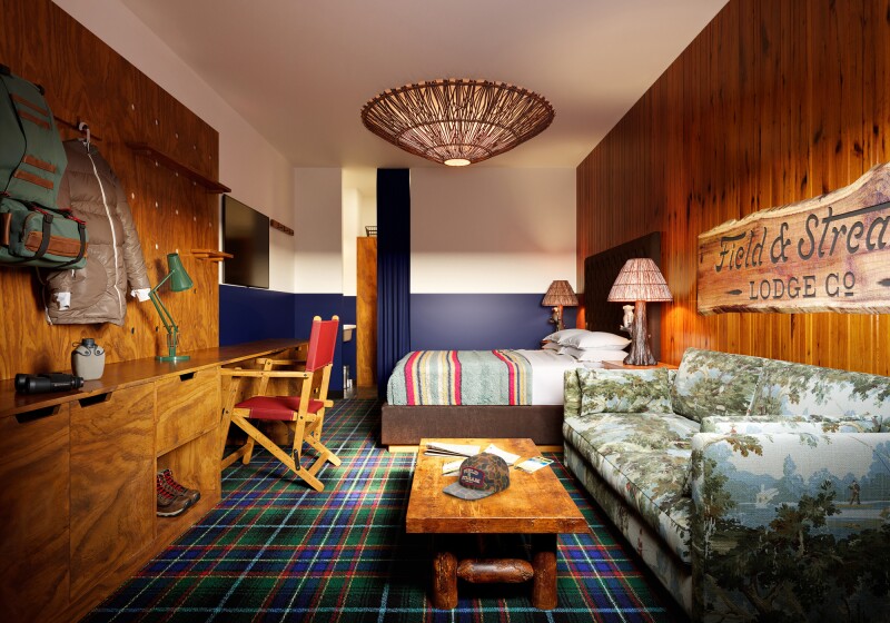 Guest room with plaid carpeting, patterned sofa, and kitschy decor