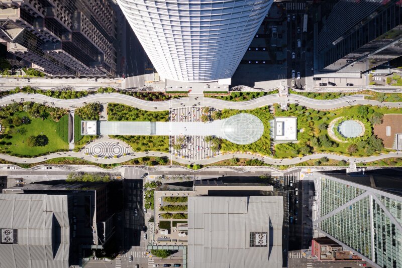 Aerial view of narrow green space between tall buildings