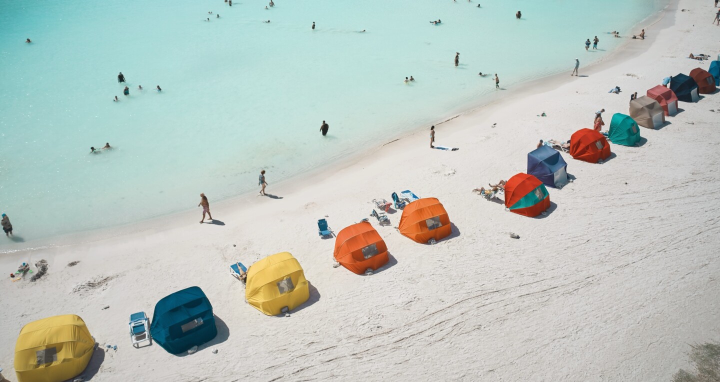 A high view of colorful sun tents in a row along Baby Beach in Aruba.